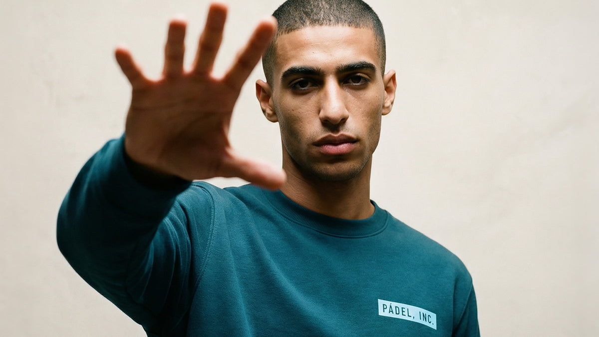 Young mediterranean man wearing Padel INC Stargazer green sweatshirt with Sky blue logo on chest