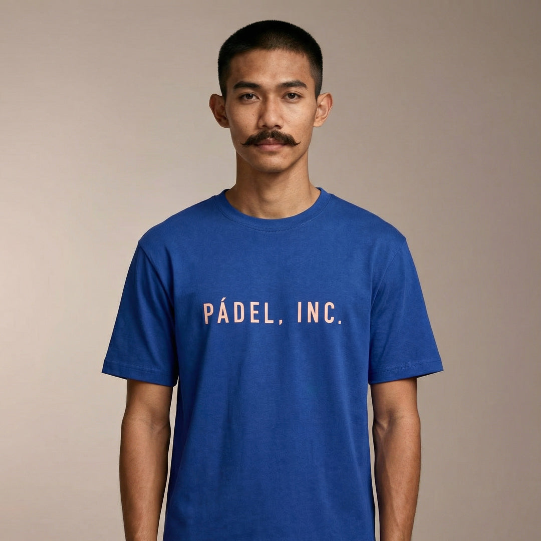 Man wearing a blue t-shirt with 'Pádel, Inc.' text on a beige background